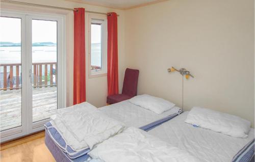 NedstrandにあるNice Home In Nedstrand With 5 Bedrooms, Sauna And Wifiのベッドルーム1室(ベッド2台付)、海を望むバルコニーが備わります。