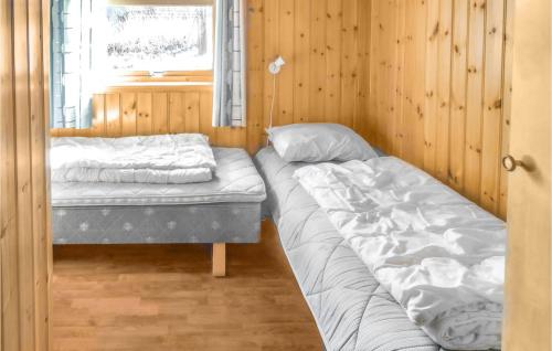 VestvikにあるBeautiful Home In Auklandshamn With 5 Bedrooms, Sauna And Private Swimming Poolのベッド2台と窓が備わる客室です。