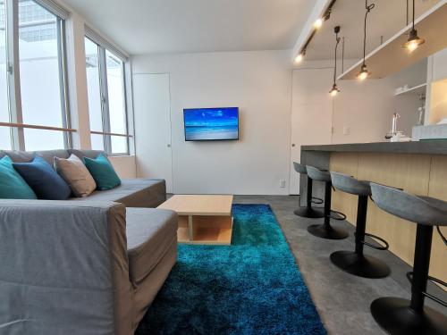 a living room with a couch and a bar at SHhotel 1フロア貸切り 広々2LDK in Naha