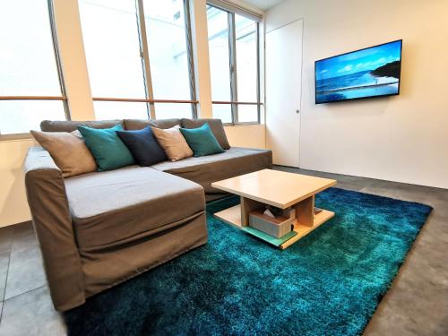 a living room with a couch and a table at SHhotel 1フロア貸切り 広々2LDK in Naha