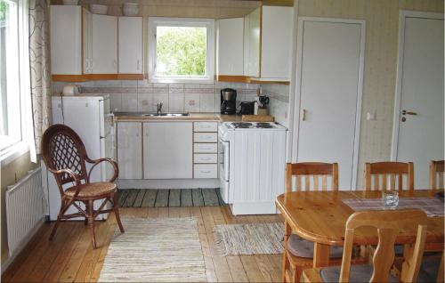 NyhamnにあるStunning Home In Visby With 3 Bedroomsの白いキャビネット、テーブルと椅子付きのキッチンが備わります。