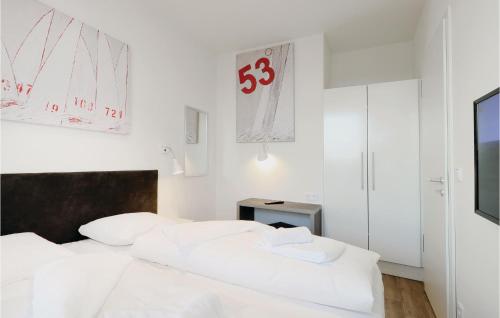 トラフェミュンデにある3 Bedroom Pet Friendly Apartment In Lbeck Travemndeの白い部屋の白いベッド2台、テレビ付