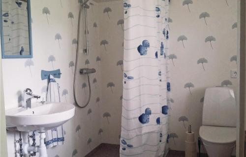 a bathroom with a sink and a shower curtain with umbrellas at Awesome Home In Brlanda With 1 Bedrooms in Sörbo