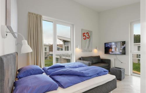 Cette chambre dispose d'un lit avec des oreillers bleus et d'une fenêtre. dans l'établissement Dnenvilla Penthouse Deluxe, à Travemünde