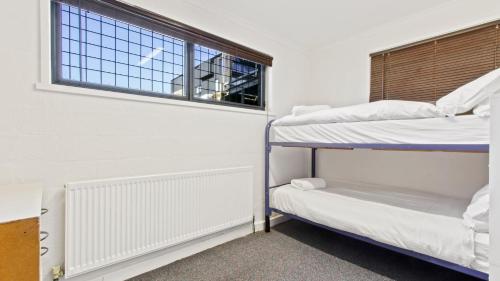 two bunk beds in a room with a window at Alpine Heights 11B in Mount Hotham