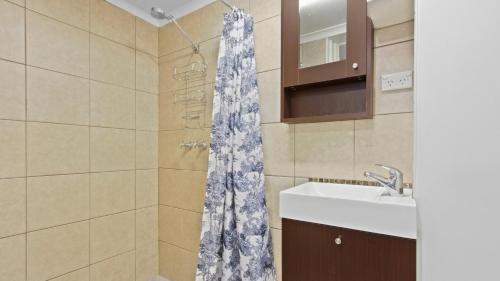 a bathroom with a shower curtain and a sink at Alpine Heights 11B in Mount Hotham