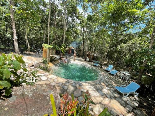 a swimming pool in a yard with chairs and a table at Recanto dos manacas in Pirenópolis