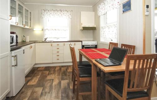 a kitchen with a table with a laptop on it at Cozy Home In Hatlestrand With Sauna in Hatlestrand