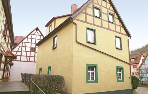 a yellow house with green windows on a building at Holiday Home Adelshofen Iii in Adelshofen