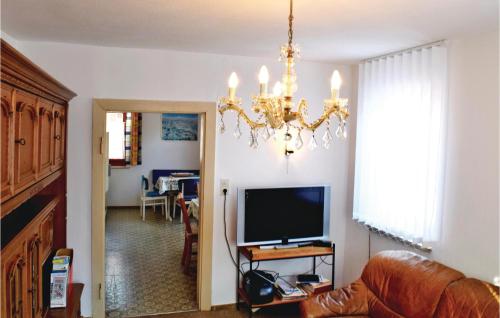 a living room with a television and a chandelier at Holiday Home Adelshofen Iii in Adelshofen