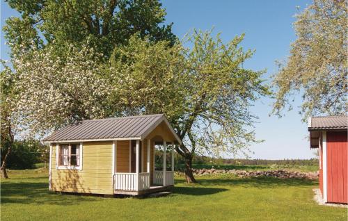 a small yellow cabin in a field with trees at Holiday Home Laxarve Boge Slite in Slite
