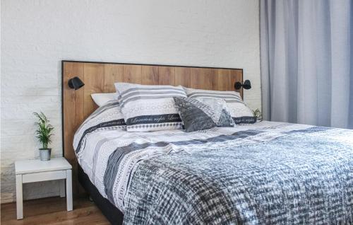 Schlafzimmer mit einem Bett mit einem Kopfteil aus Holz und Kissen in der Unterkunft Aquadelta Bruinisse-clipper 26 in Bruinisse