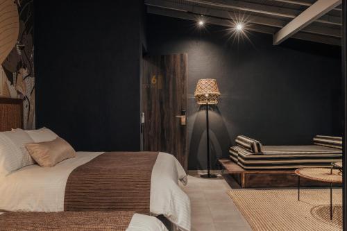 a bedroom with a bed and a couch and a lamp at Sui Boutique Hotel in Medellín