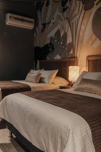 two beds in a hotel room with a wallpaper at Sui Boutique Hotel in Medellín