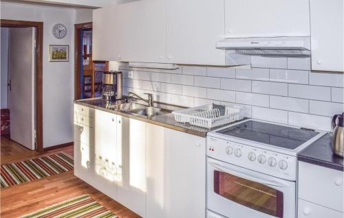 a white kitchen with a sink and a stove at Two-Bedroom Holiday Home In Orkelljunga in Orkelljunga