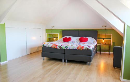 Udenhout的住宿－Awesome Home In Udenhout With House A Panoramic View，一间卧室配有一张带红色枕头的床