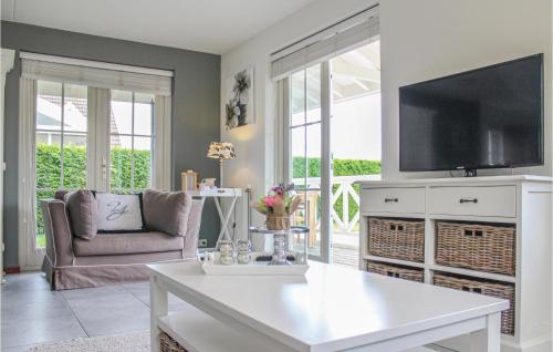 a living room with a white table and a tv at 3 Bedroom Cozy Home In Wemeldinge in Wemeldinge