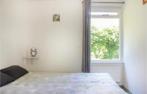 a bedroom with a bed and a window at Awesome Home In Lauwersoog With Kitchen in Lauwersoog