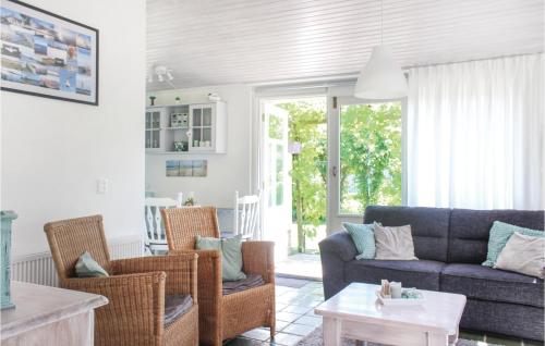a living room with a blue couch and chairs at Awesome Home In Lauwersoog With Kitchen in Lauwersoog