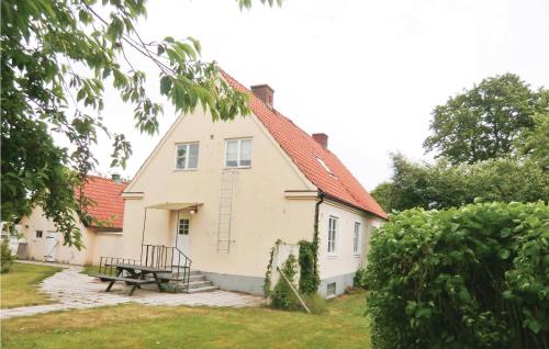 a house with a picnic table in front of it at Nice Home In Tomelilla With Kitchen in Tomelilla