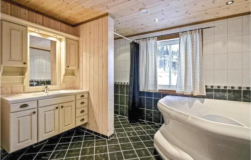 uma casa de banho com uma banheira, um lavatório e um WC. em Skarsnuten em Hemsedal