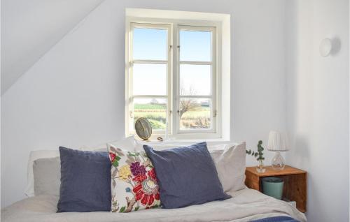 a white couch with pillows in front of a window at 1 Bedroom Beautiful Apartment In Vellinge in Vellinge