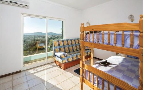 a bedroom with a bunk bed and a couch and a window at Amazing Home In S,brs De Alportel With Kitchen in Almargens