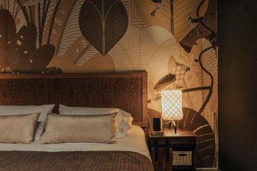 a bedroom with a bed and a lamp on a table at Sui Boutique Hotel in Medellín