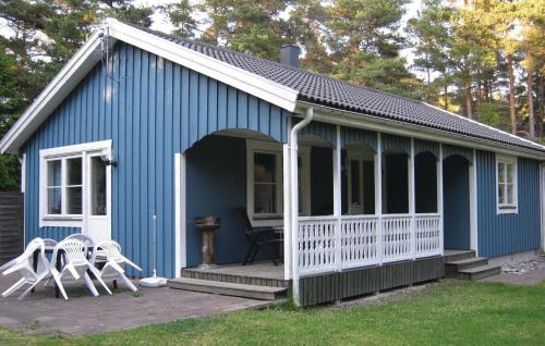 a blue shed with two white chairs on a porch at 3 Bedroom Stunning Home In Slite in Slite