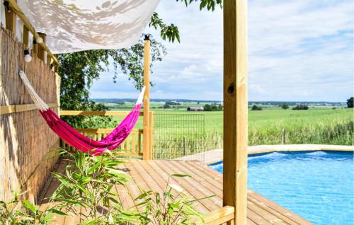 a hammock on a deck next to a pool at Lovely Home In ngelholm With Outdoor Swimming Pool in Ängelholm