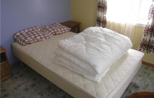 Una cama con sábanas blancas en un dormitorio en Gunhildhus, en Vangsnes