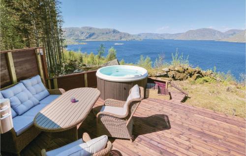 a patio with a hot tub and a table and chairs at Nice Home In Farsund With Wifi in Farsund
