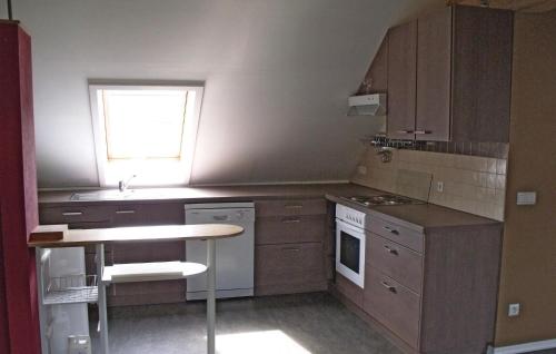 a kitchen with wooden cabinets and a table and a window at Fleur De Lys in Burg-Reuland