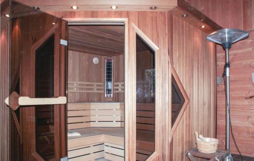 a sauna with wooden walls and a glass door at De Koestal in Wijdenes