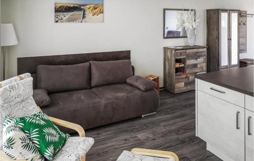 a living room with a brown couch and a kitchen at Beautiful Apartment In Graal-Müritz in Graal-Müritz
