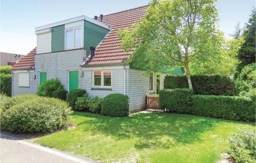 a house with a green roof and a yard at Awesome Home In Wemeldinge With Kitchen in Wemeldinge