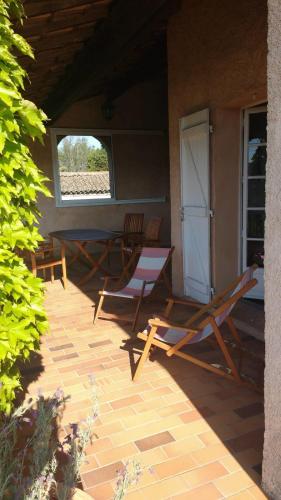 deux chaises et une table sur une terrasse dans l'établissement DUPLEX 130 m avec TERRASSE - centre du village, à Bagnols-en-Forêt