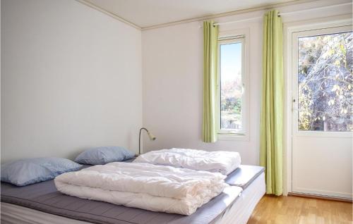 Schlafzimmer mit einem Bett mit weißer Bettwäsche und einem Fenster in der Unterkunft Lovely Home In Forsand With House Sea View in Jørpeland