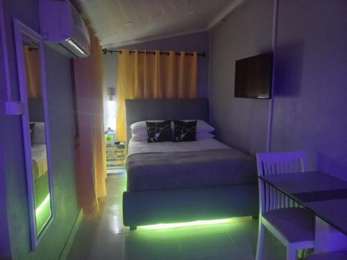 - une chambre avec un lit dans une chambre violette dans l'établissement The Brayan's Apartment, à Oranjestad