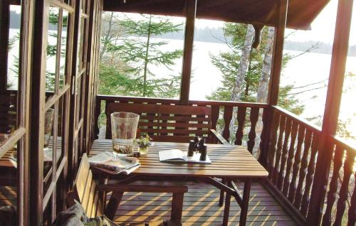 a wooden table sitting on a porch with a window at Sjöstugan in Pålsmåla