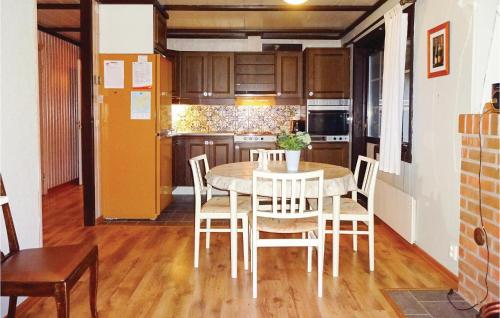 a kitchen with a table and chairs in a room at Four-Bedroom Holiday Home In Hasslo in Sissehall