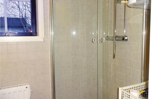 a shower with a glass door in a bathroom at Four-Bedroom Holiday Home In Hasslo in Sissehall