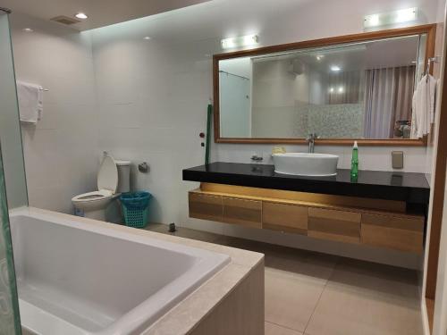 a bathroom with a tub and a sink and a mirror at Hotel,Căn Hộ Mũi Né Sea link in Phan Thiet