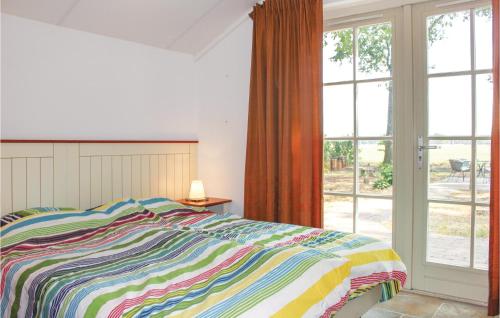 een slaapkamer met een bed en een groot raam bij Beautiful Home In Hoge Hexel With Kitchen in Hoge-Hexel