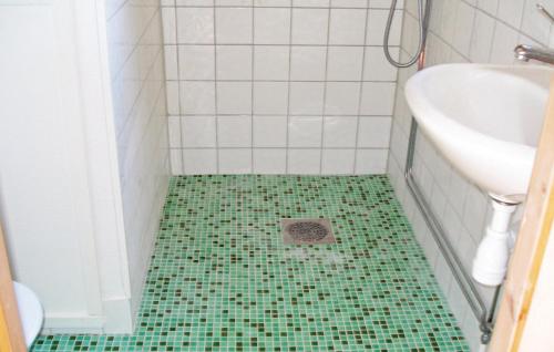 a bathroom with a green tiled floor and a sink at Beautiful Home In smo With 2 Bedrooms in Ösmo