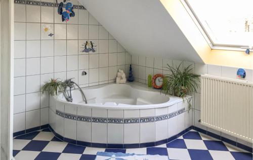 a large bath tub in a bathroom with a tile floor at Monas Natur-oase in Manderfeld