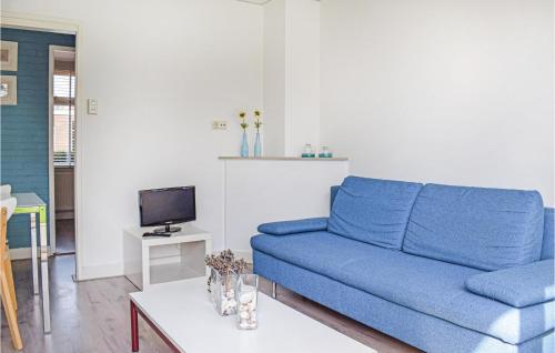 a living room with a blue couch and a tv at De Eekhof - Appartement Tuin in Hindeloopen