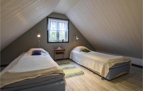 1 dormitorio en el ático con 2 camas y ventana en Pet Friendly Home In Visby With Kitchen, en Endre