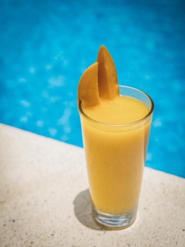 a glass of orange juice with a plastic star at Elements Tulum Boutique Hotel in Tulum
