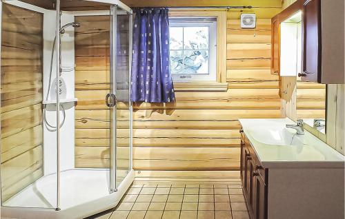 a bathroom with wooden walls and a shower and a sink at Skarsnuten in Hemsedal